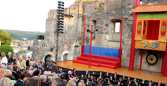 Das Orchester ist bereit und auch die letzten Zuschauer nehmen ihre Plätze vor dem imposanten Bühnenbild ein.
